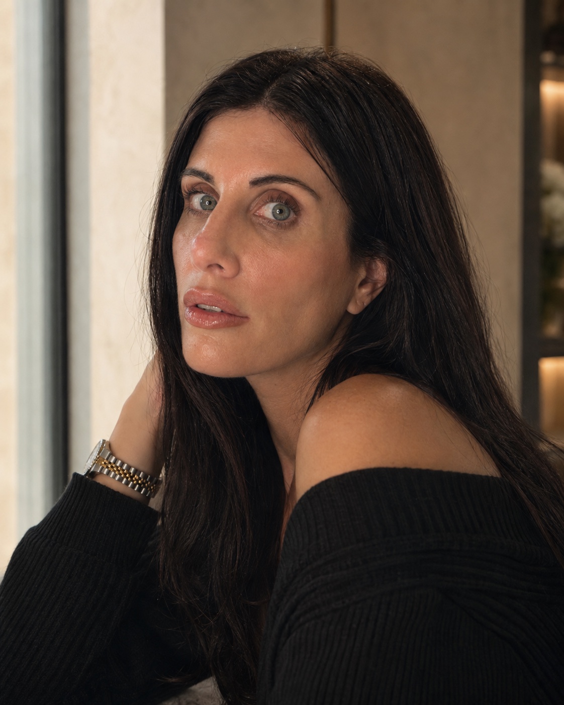 Editorial portrait of Melissa Ann Wynne in a black off-shoulder knit, looking toward the camera